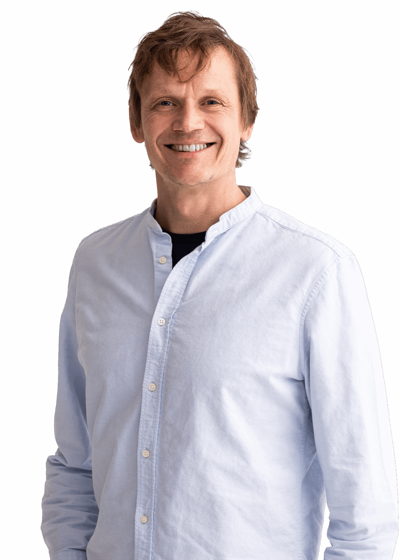 Portrait von Gilbert Kapaurer in einem weißen Shirt, er hat hellbraune Haare im Kurzhaarschnitt und lächelt breit.