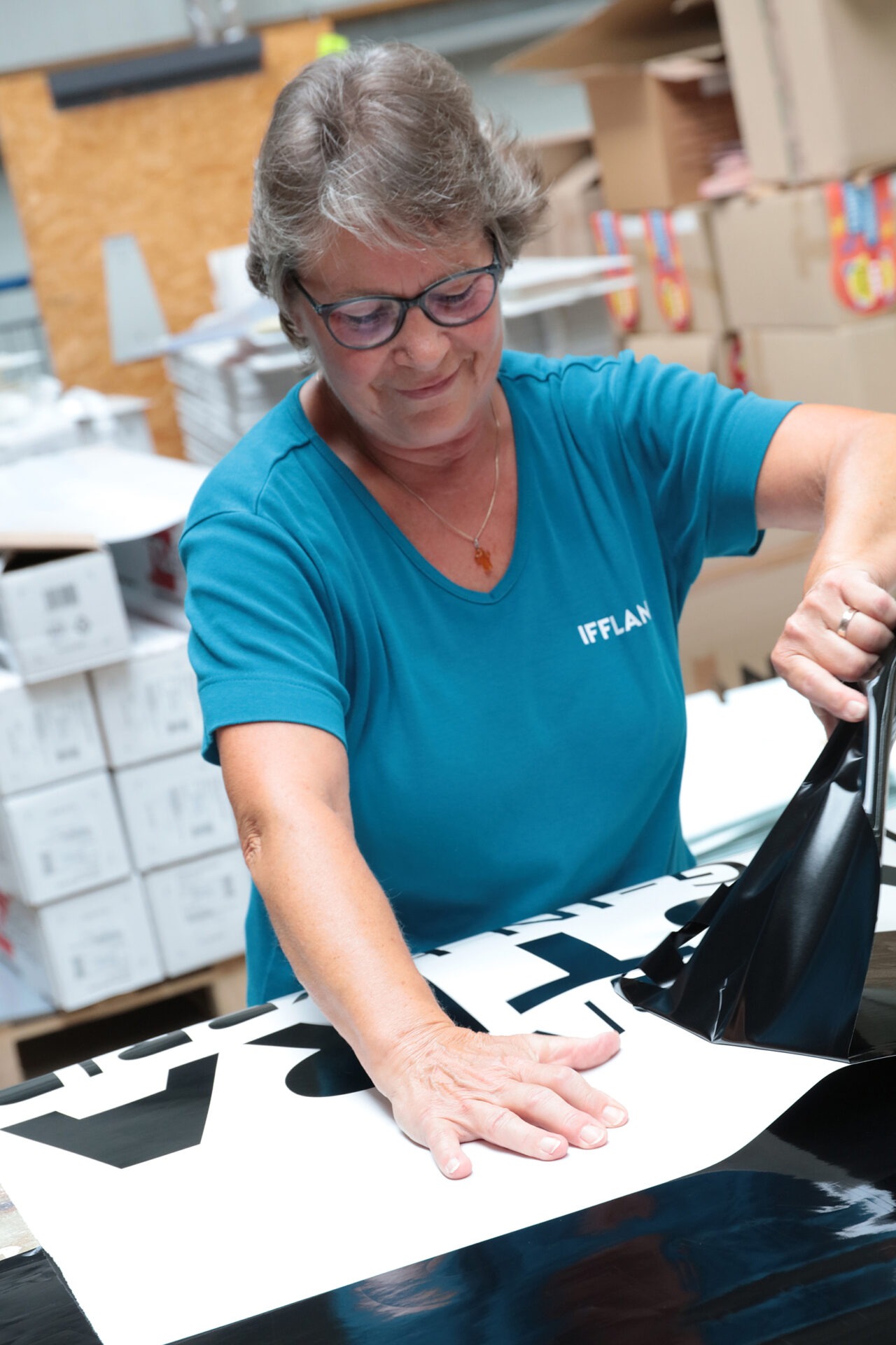 Mitarbeiterin von IFFLAND beim Entgittern eines schwarz-gedruckten Textes.